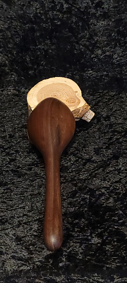 Walnut wood spoon side view on log