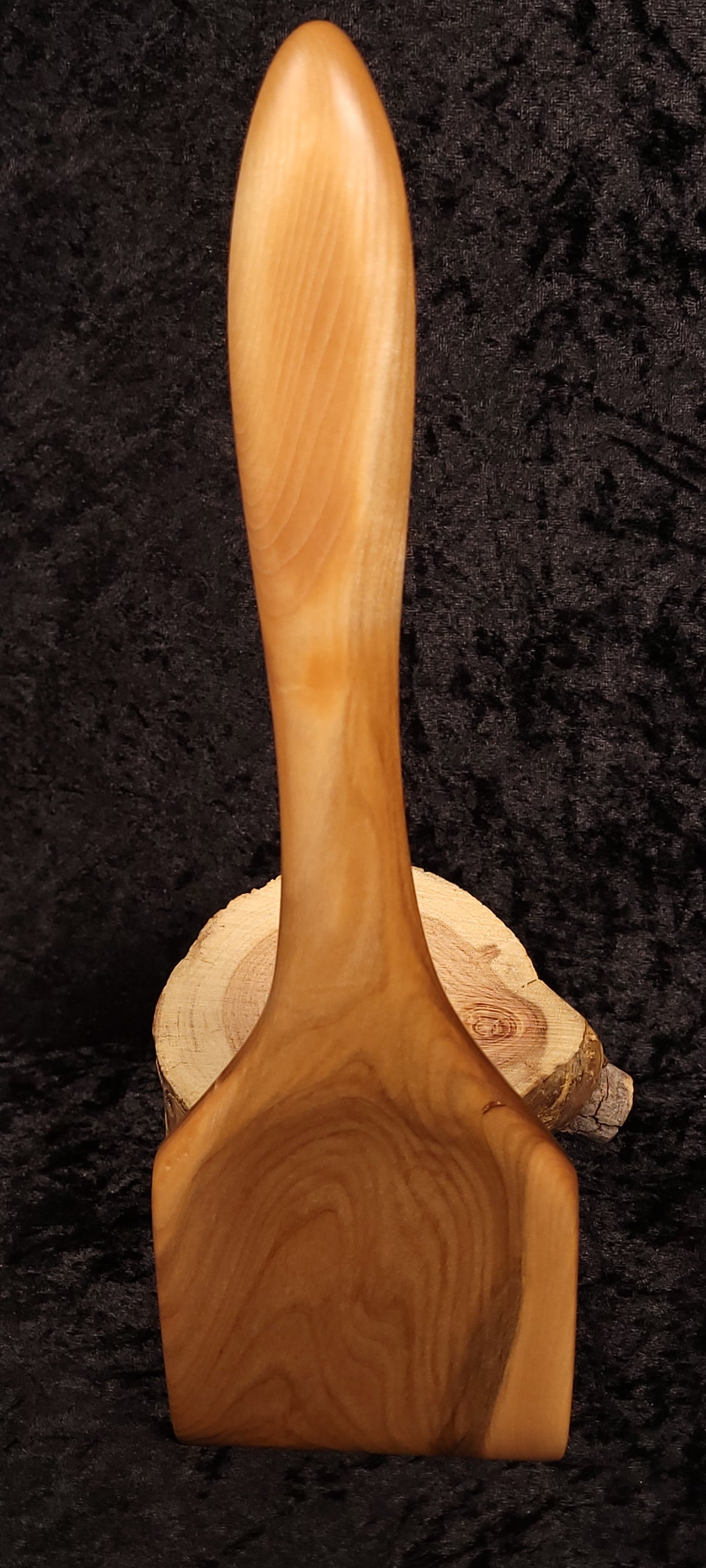 Curly maple spoon held showing low angle