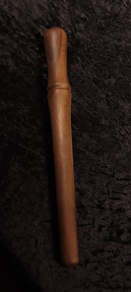 Walnut spurtle front view on dark background