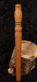 Hand-turned cherry wood rolling pin leaning on log stump - side view 1