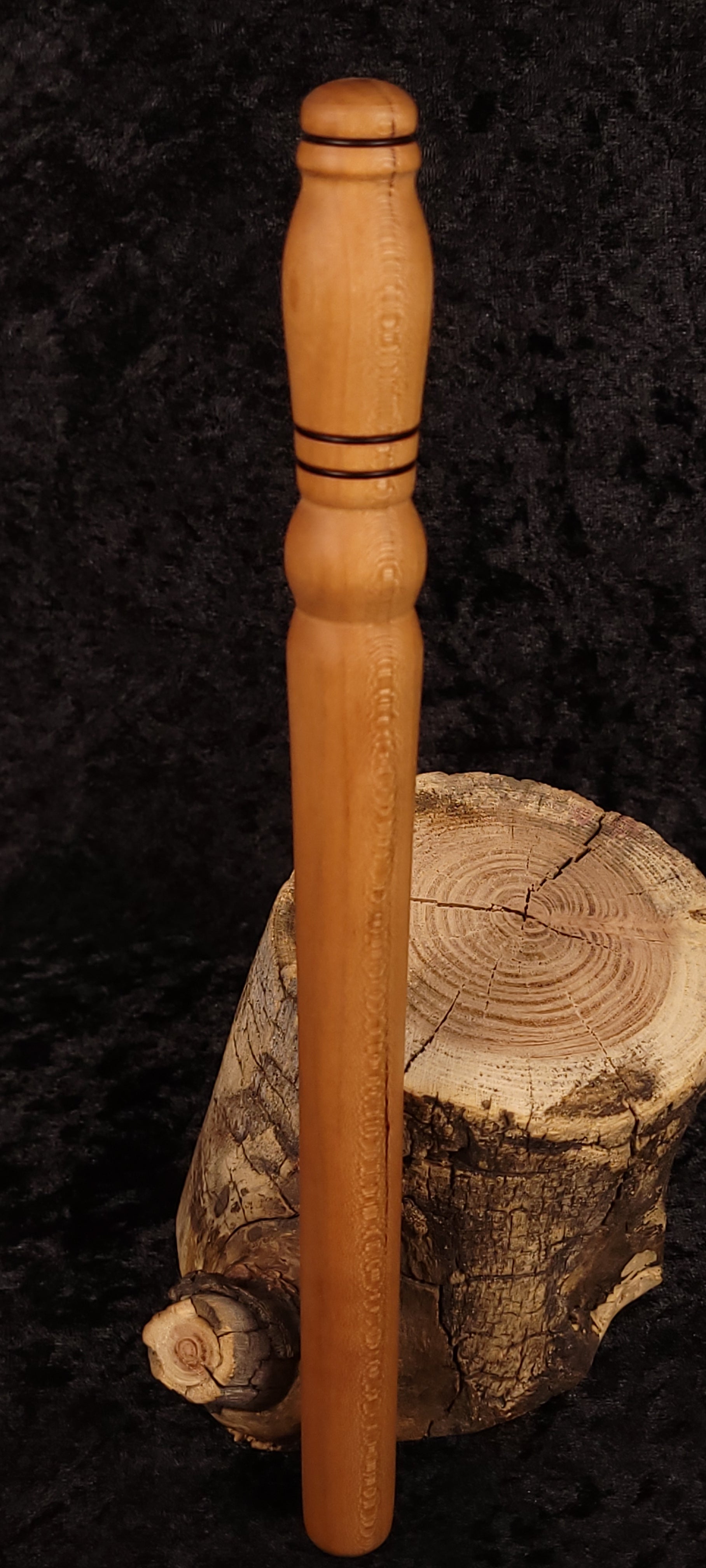 Hand-turned cherry wood rolling pin leaning on log stump - side view 3