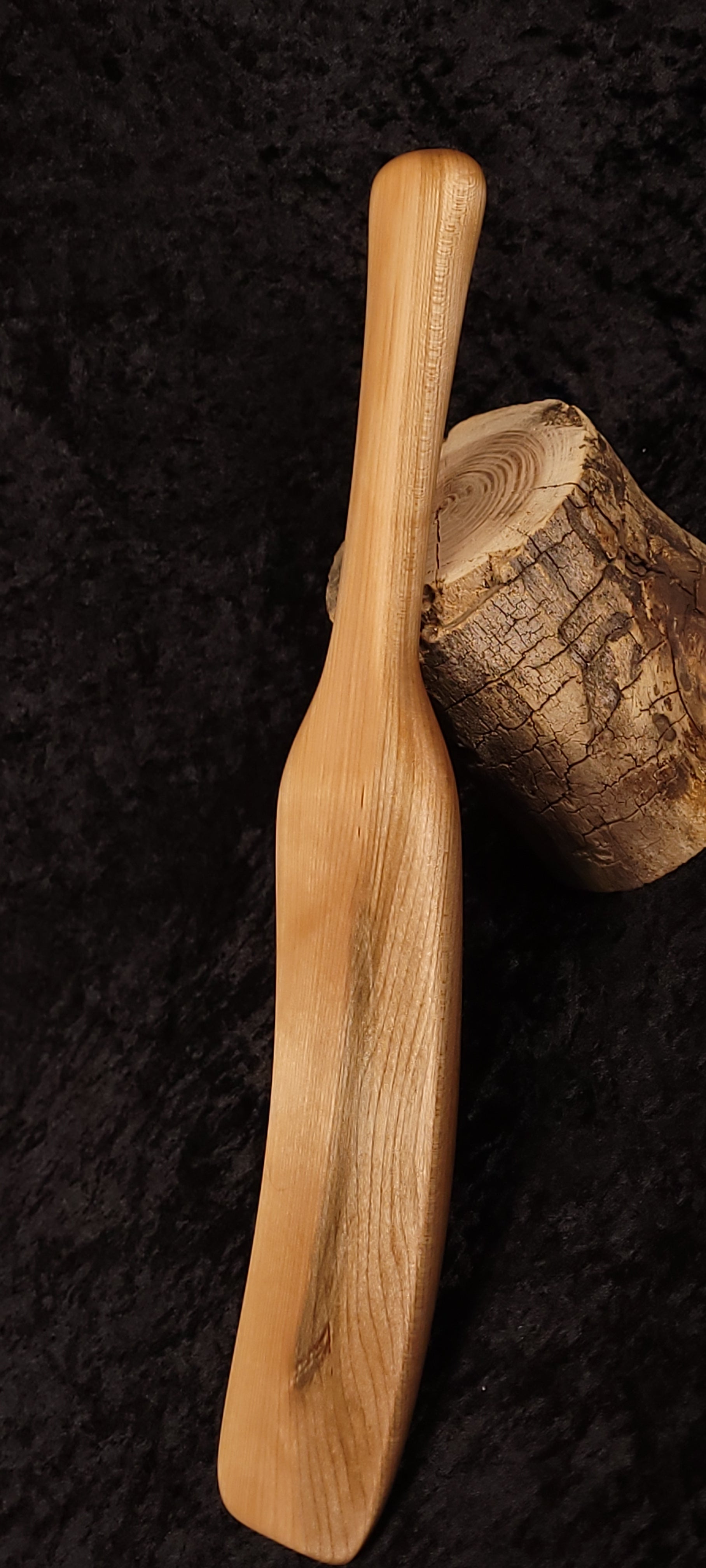 Curly maple spatula horizontal view on log