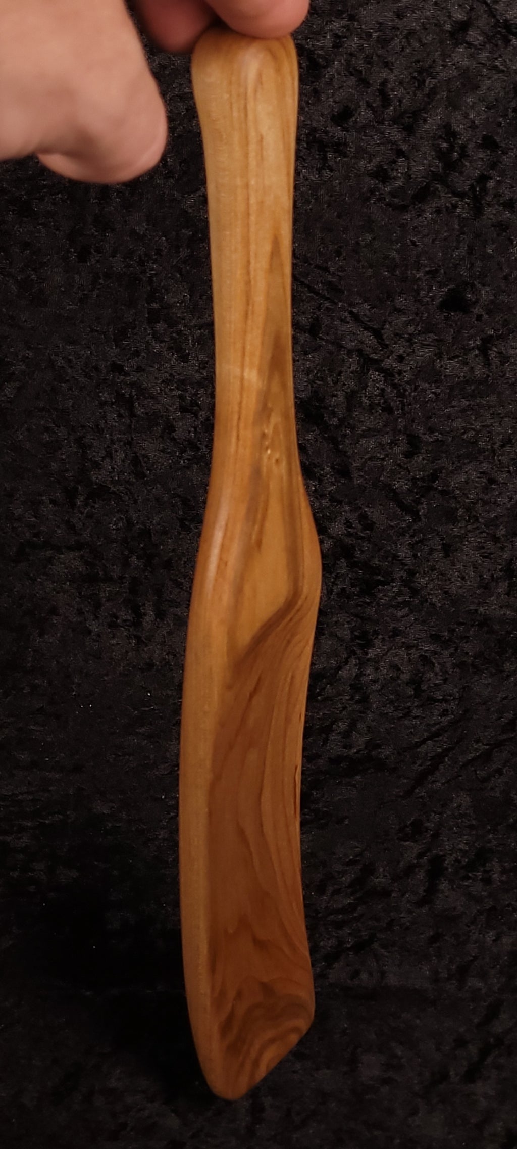 Curly maple spatula held in hand showing grain detail