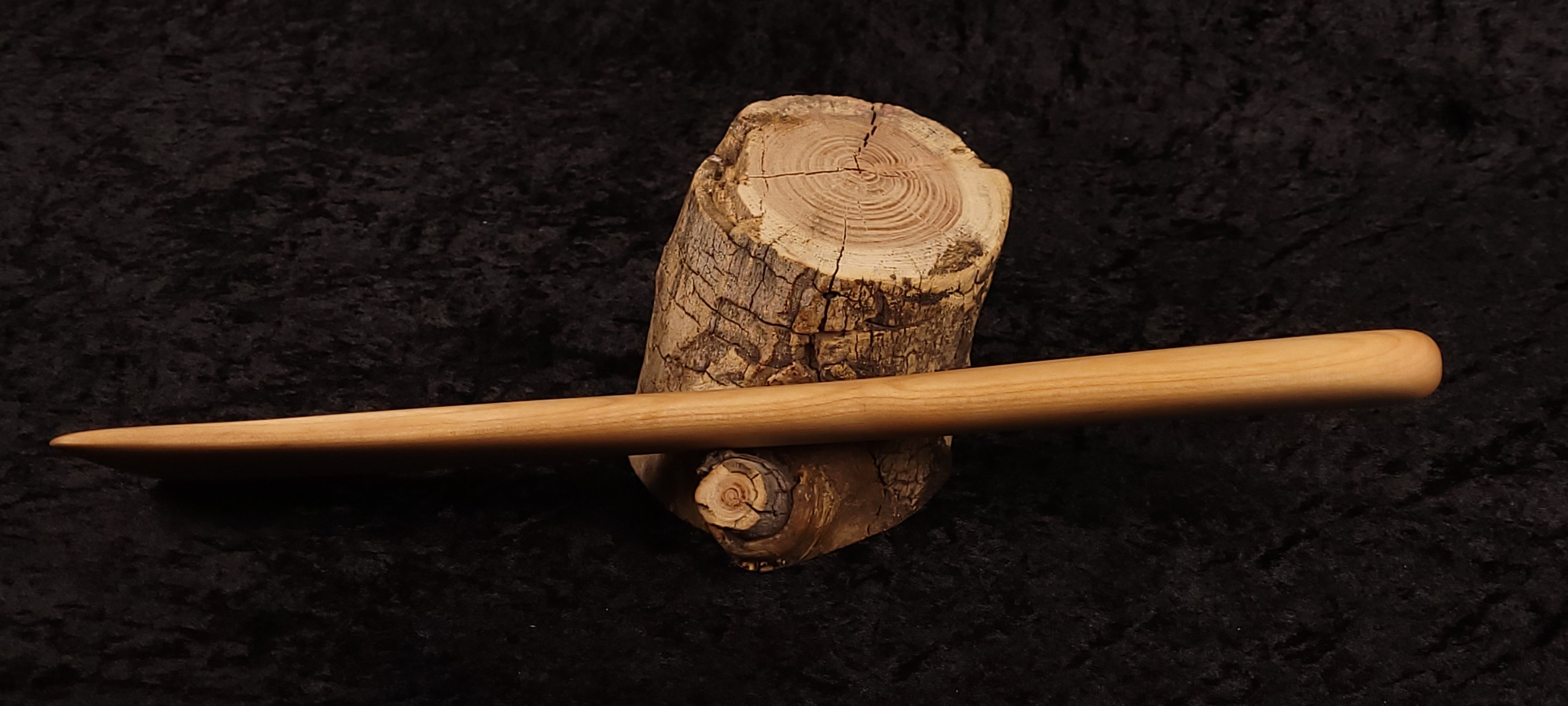 Maple wood butter spreader spurtle balanced on a log