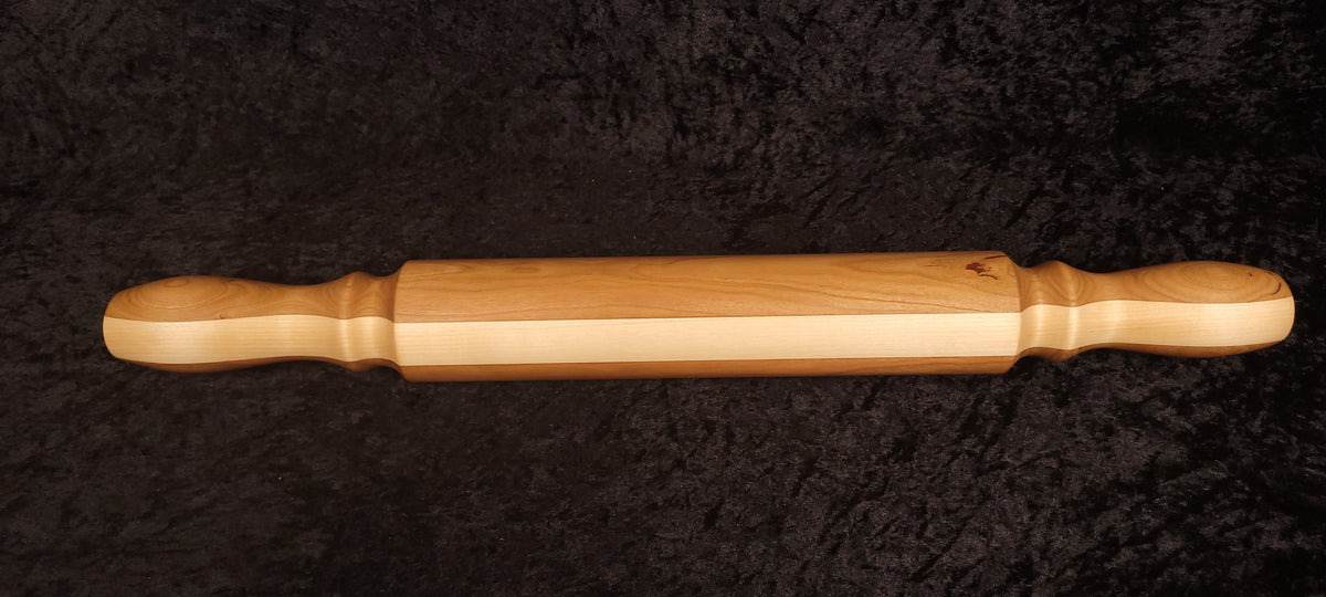 Rolling pin held vertically showing handle detail and grain