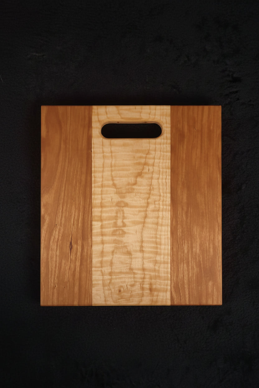 Cherry and curly maple cutting board, front face showing figured maple center stripe