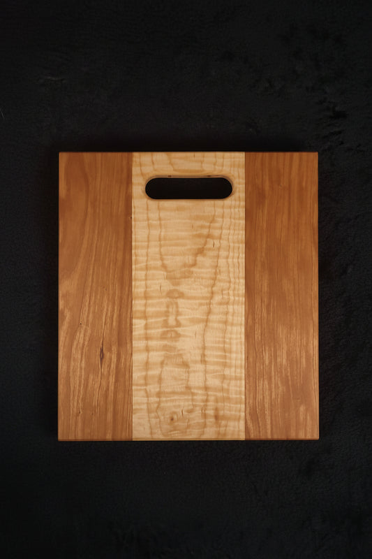 Cherry and curly maple cutting board, front face showing figured maple center stripe