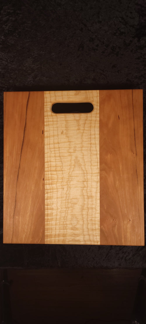 Cherry and curly maple cutting board front face, alternate angle showing character marks