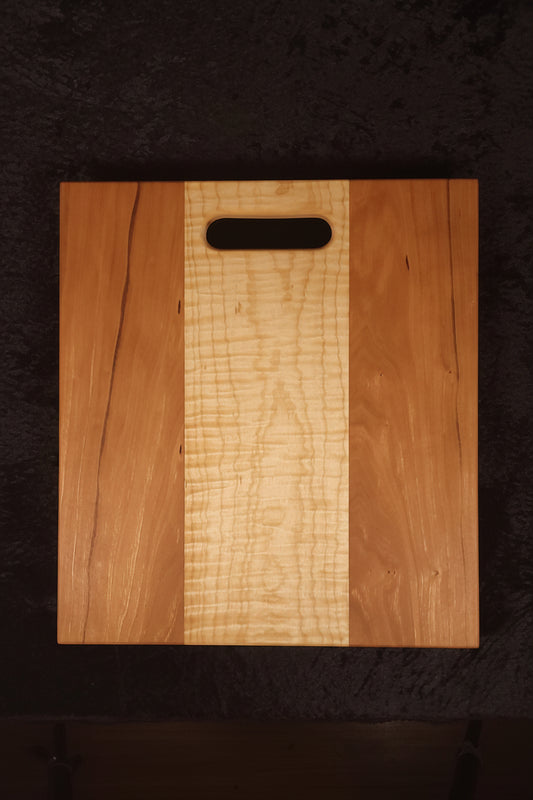 Cherry and curly maple cutting board front face, alternate angle showing character marks