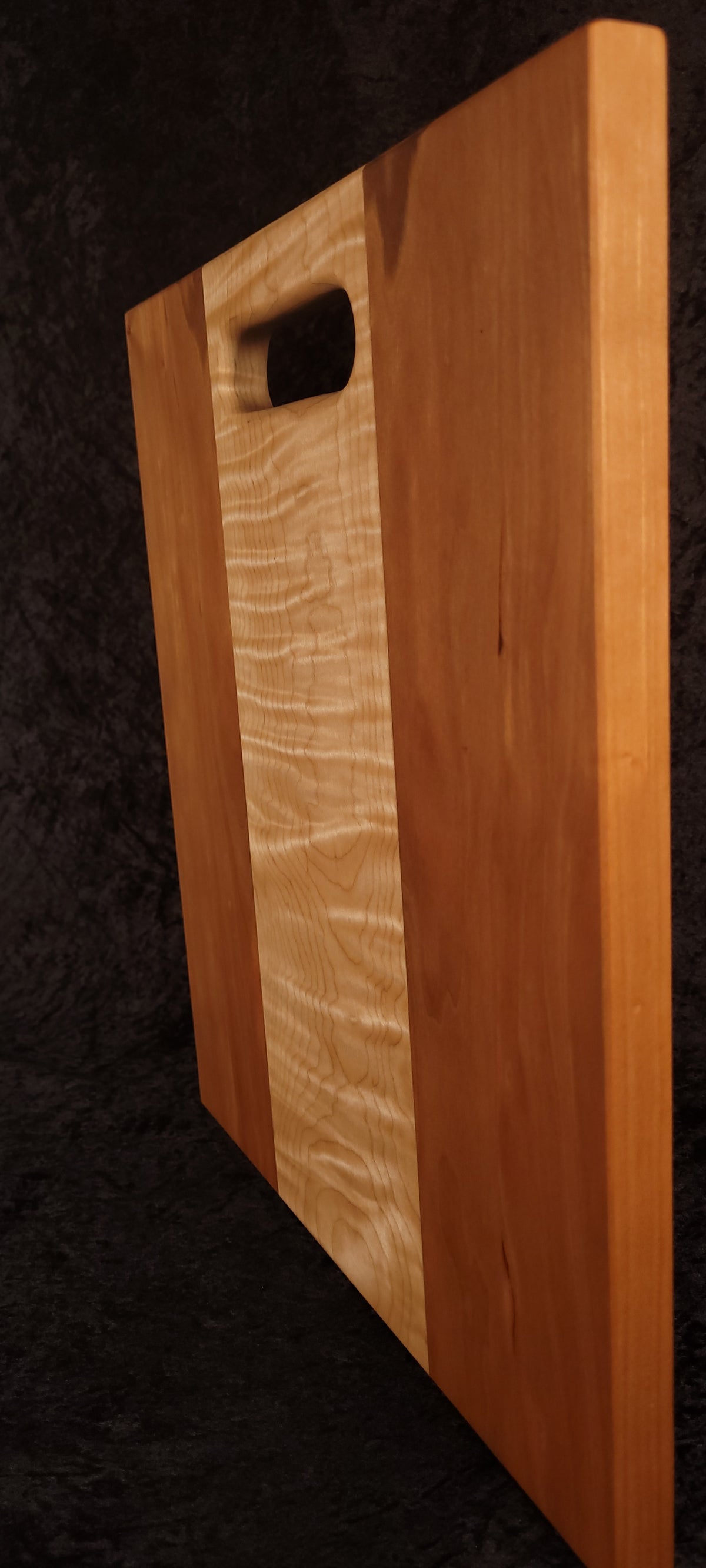 Cutting board standing on edge showing thickness and curly maple stripe