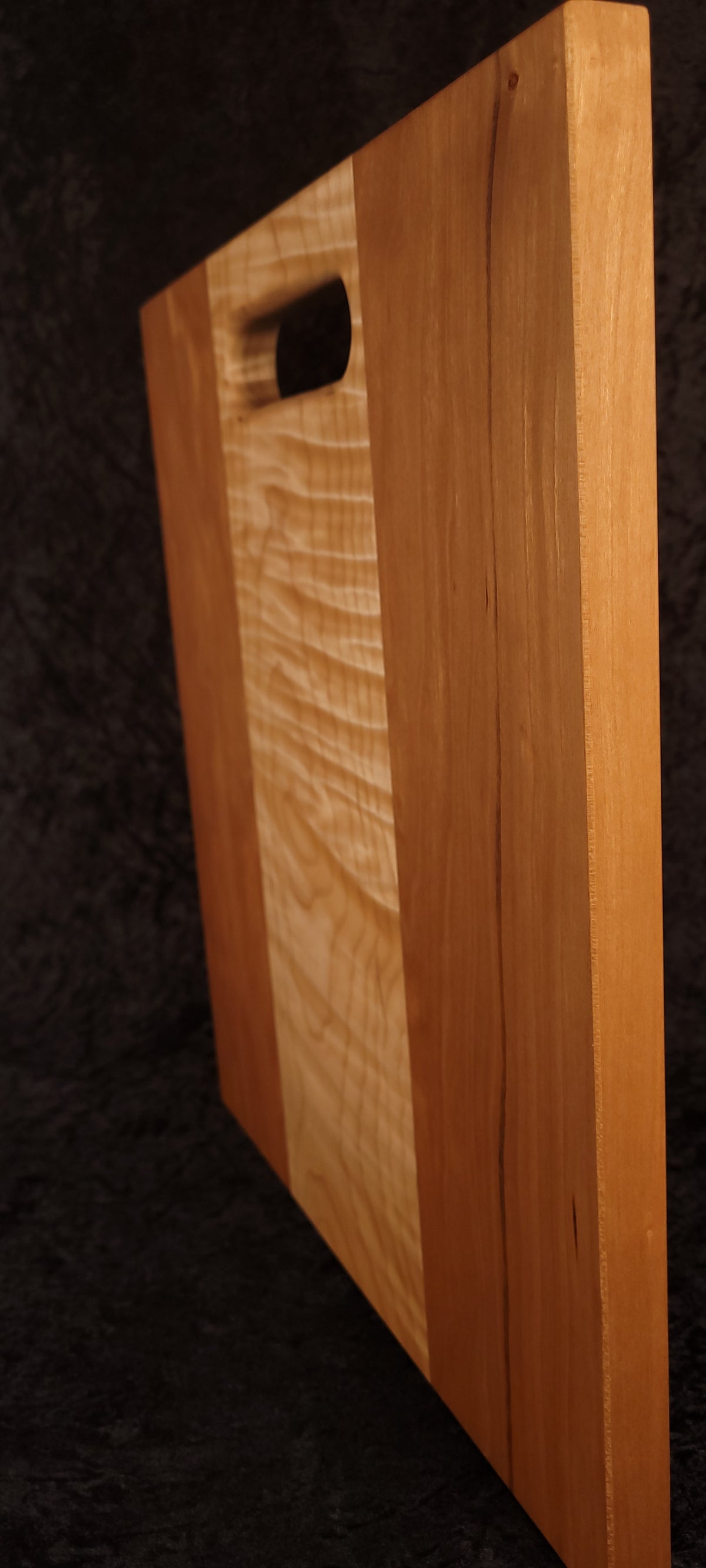 Cutting board standing on opposite edge showing cherry grain and character detail