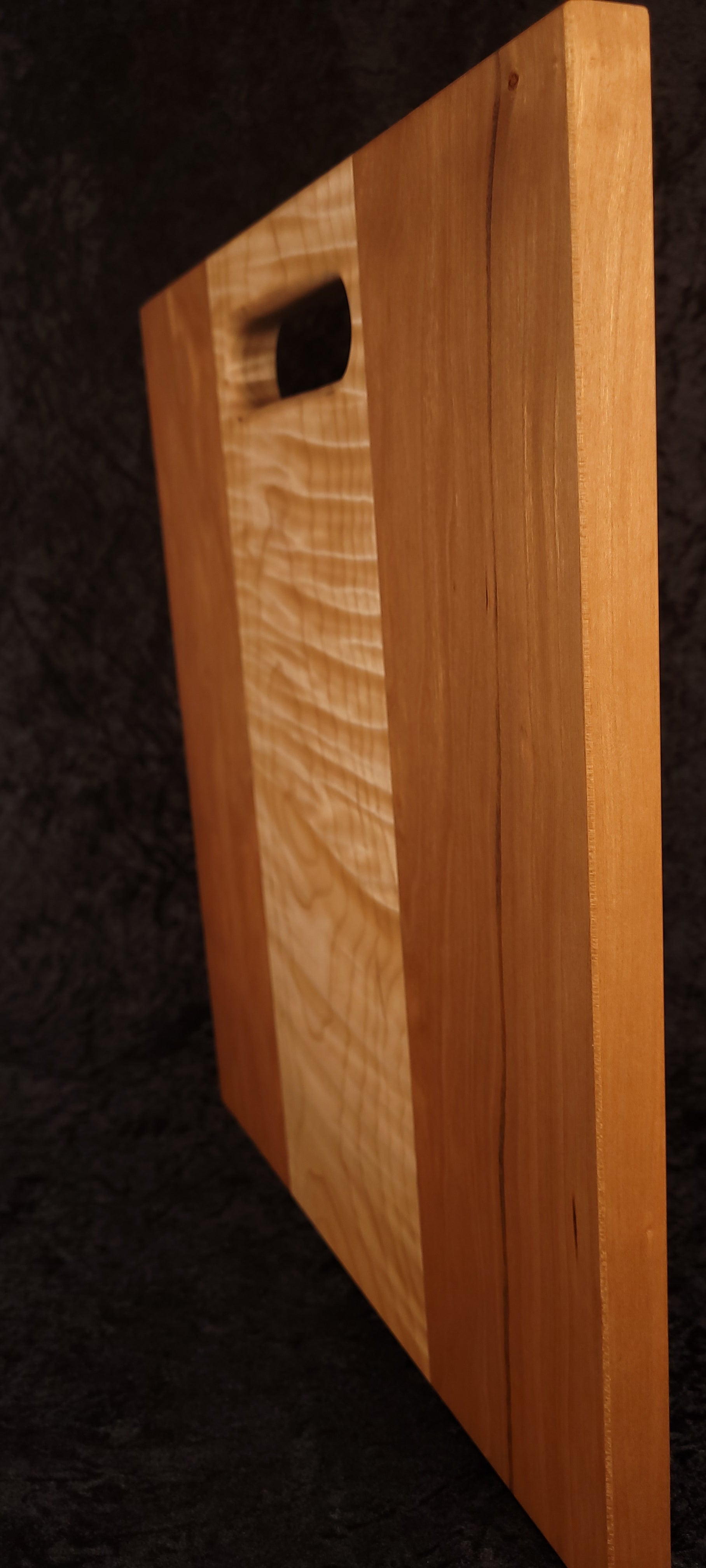 Cutting board standing on opposite edge showing cherry grain and character detail