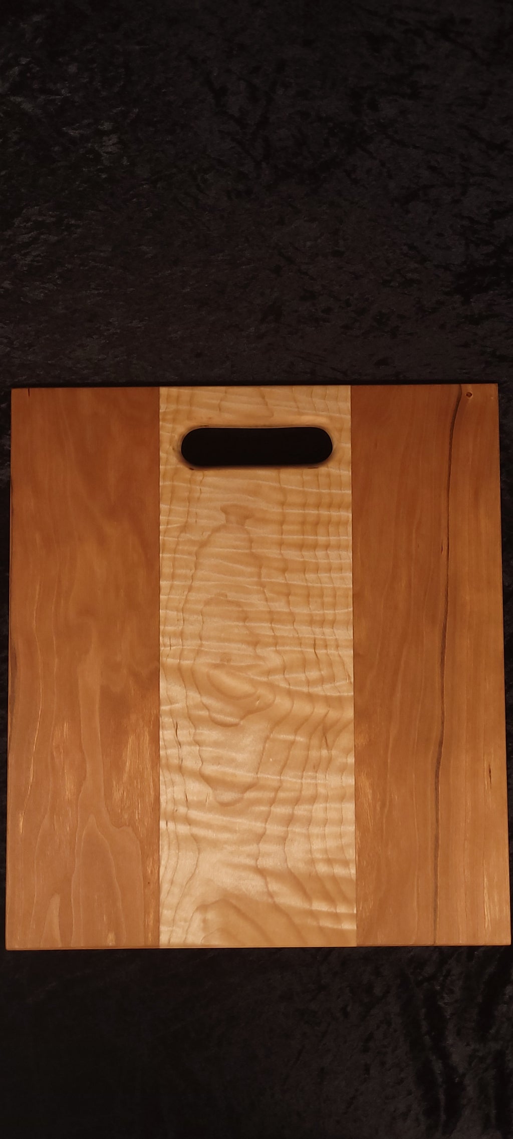 Cherry and curly maple cutting board face showing deep rippling curly maple center