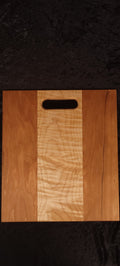 Cherry and curly maple cutting board face showing deep rippling curly maple center