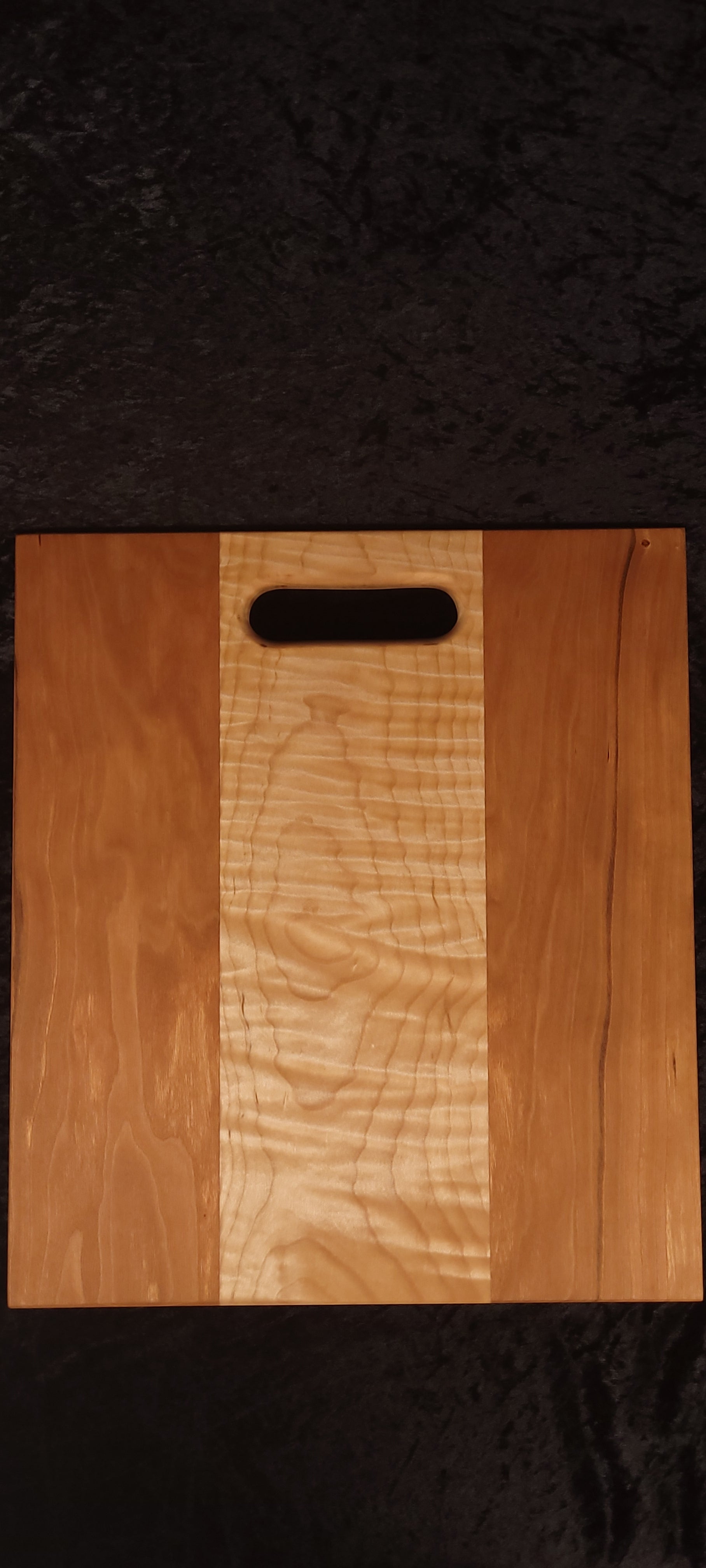 Cherry and curly maple cutting board face showing deep rippling curly maple center