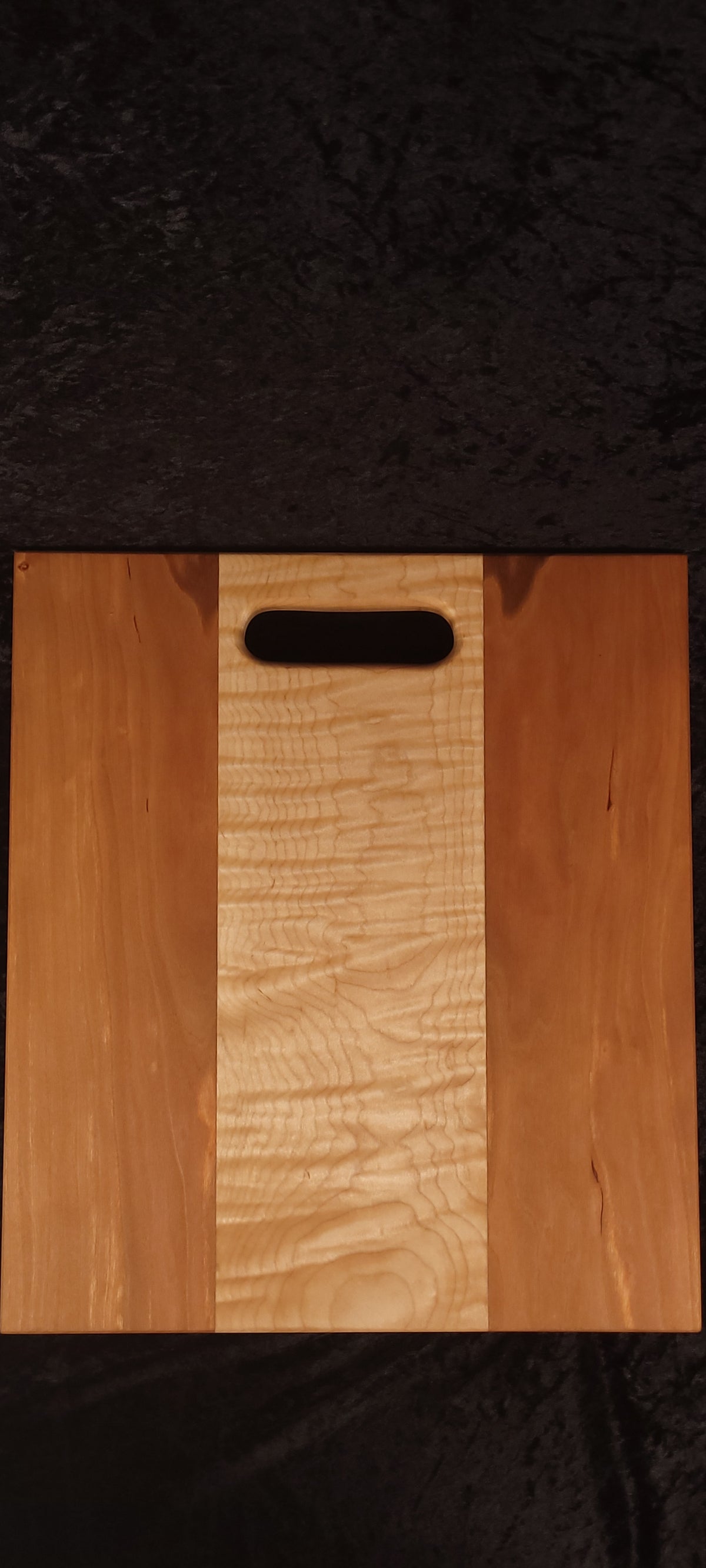 Cherry and curly maple cutting board face, alternate angle showing cathedral grain pattern