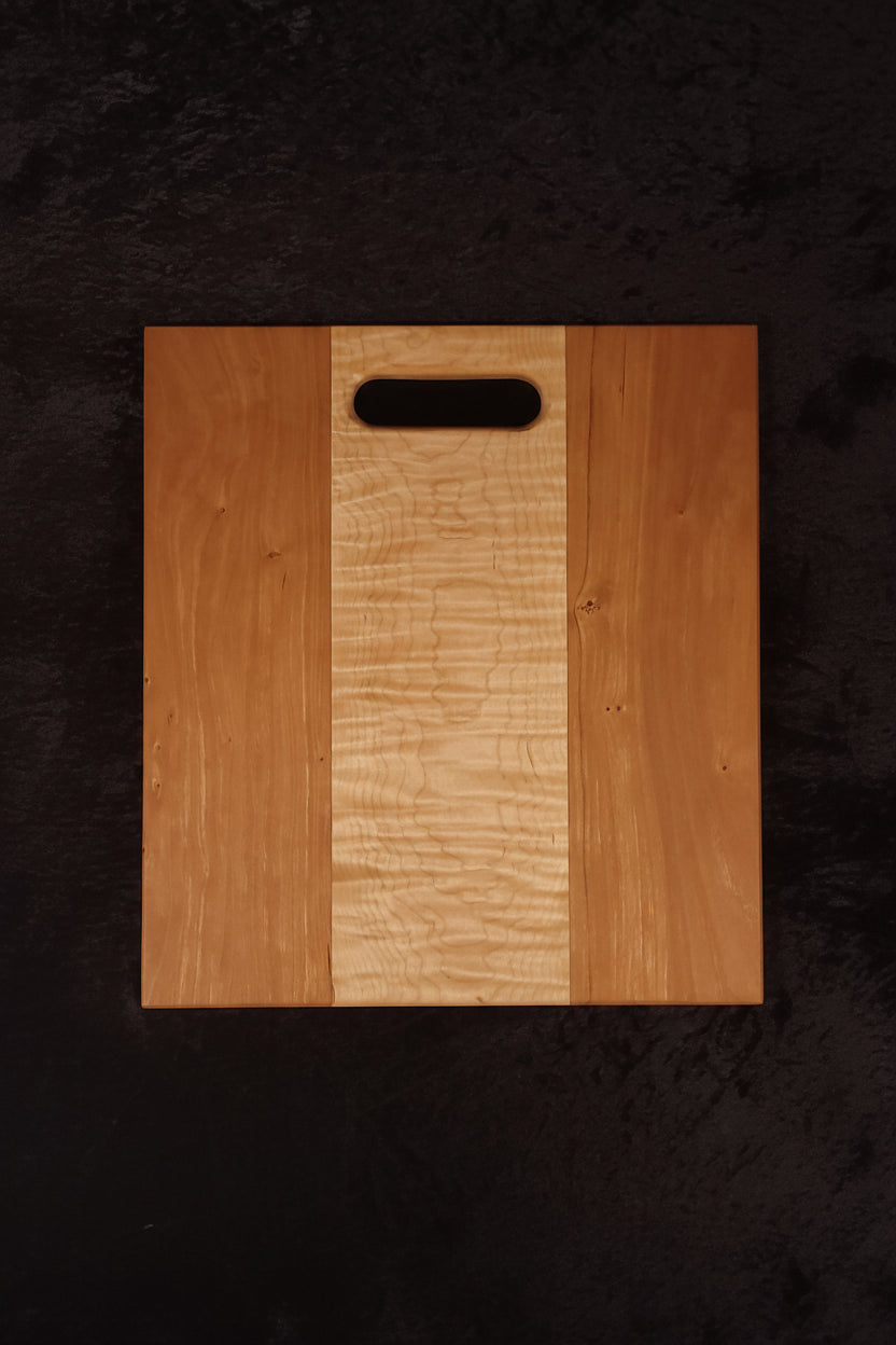 Cherry and curly maple cutting board face showing clean curly maple center stripe