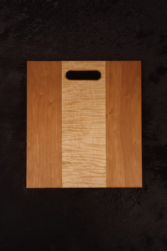Cherry and curly maple cutting board face showing clean curly maple center stripe