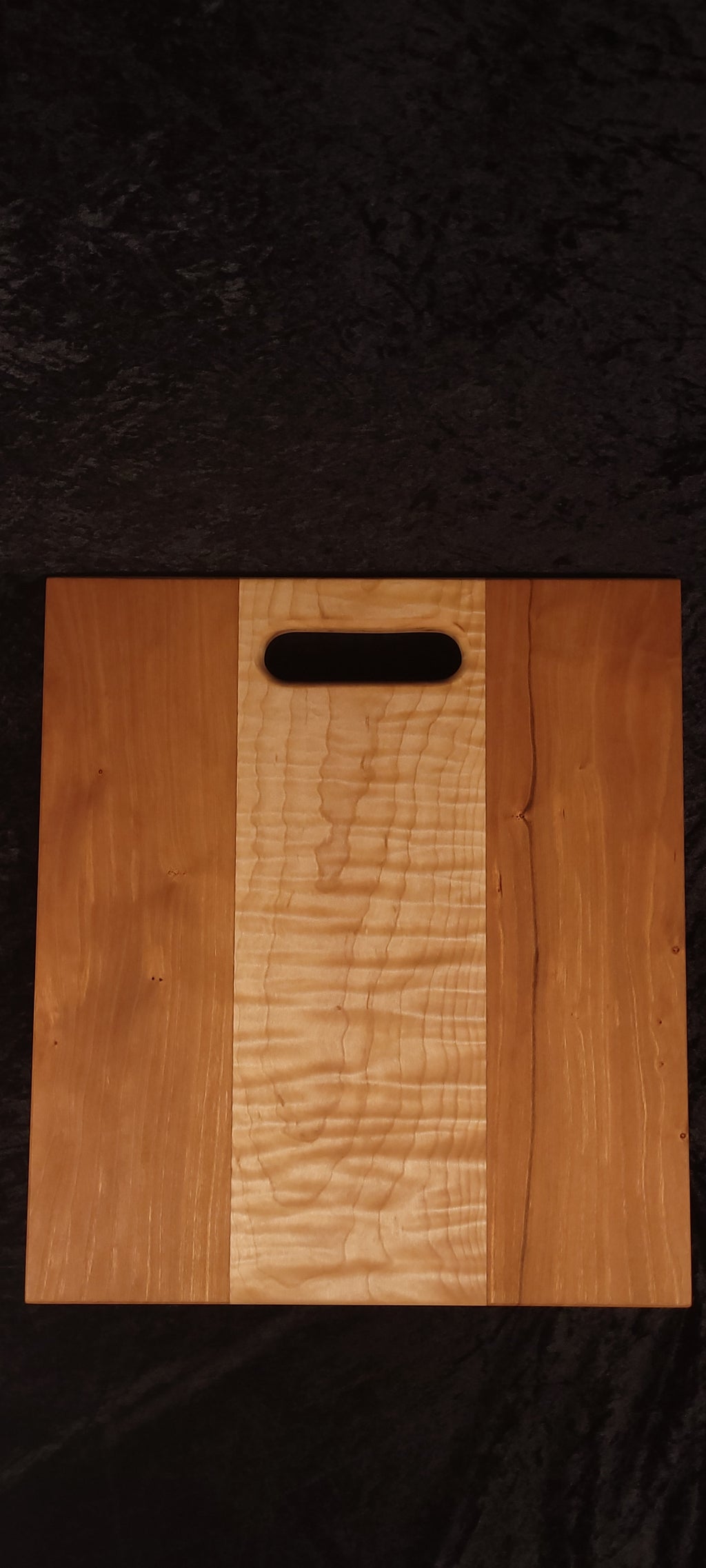 Cherry and curly maple cutting board face, alternate angle showing even cherry panels