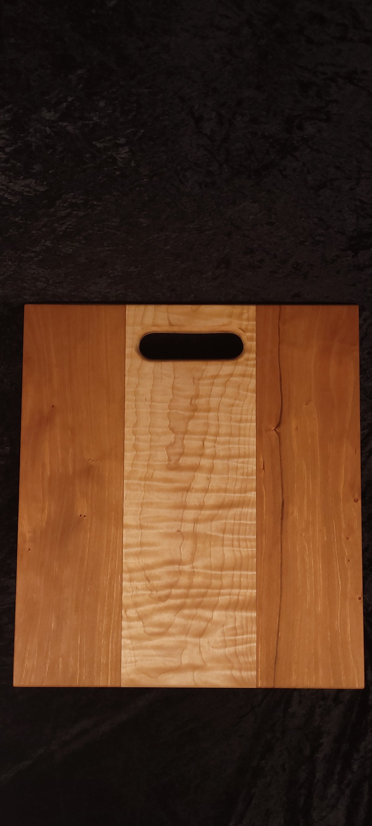 Cherry and curly maple cutting board face, alternate angle showing even cherry panels