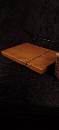 Cherry cheese board angled lifestyle shot with black stainless wire cutter and cheese