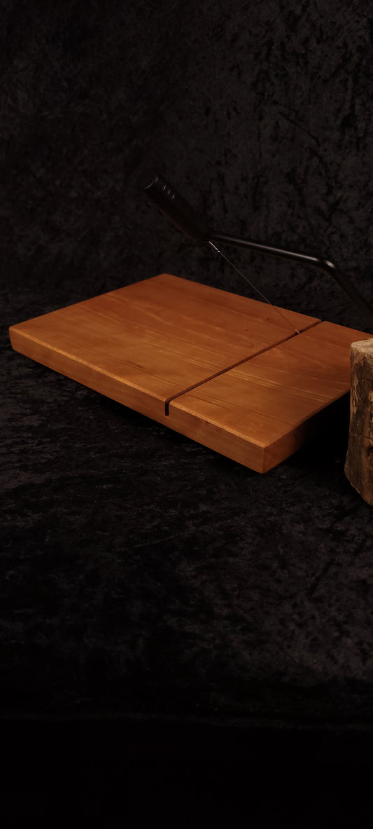 Cherry cheese board angled lifestyle shot with black stainless wire cutter and cheese