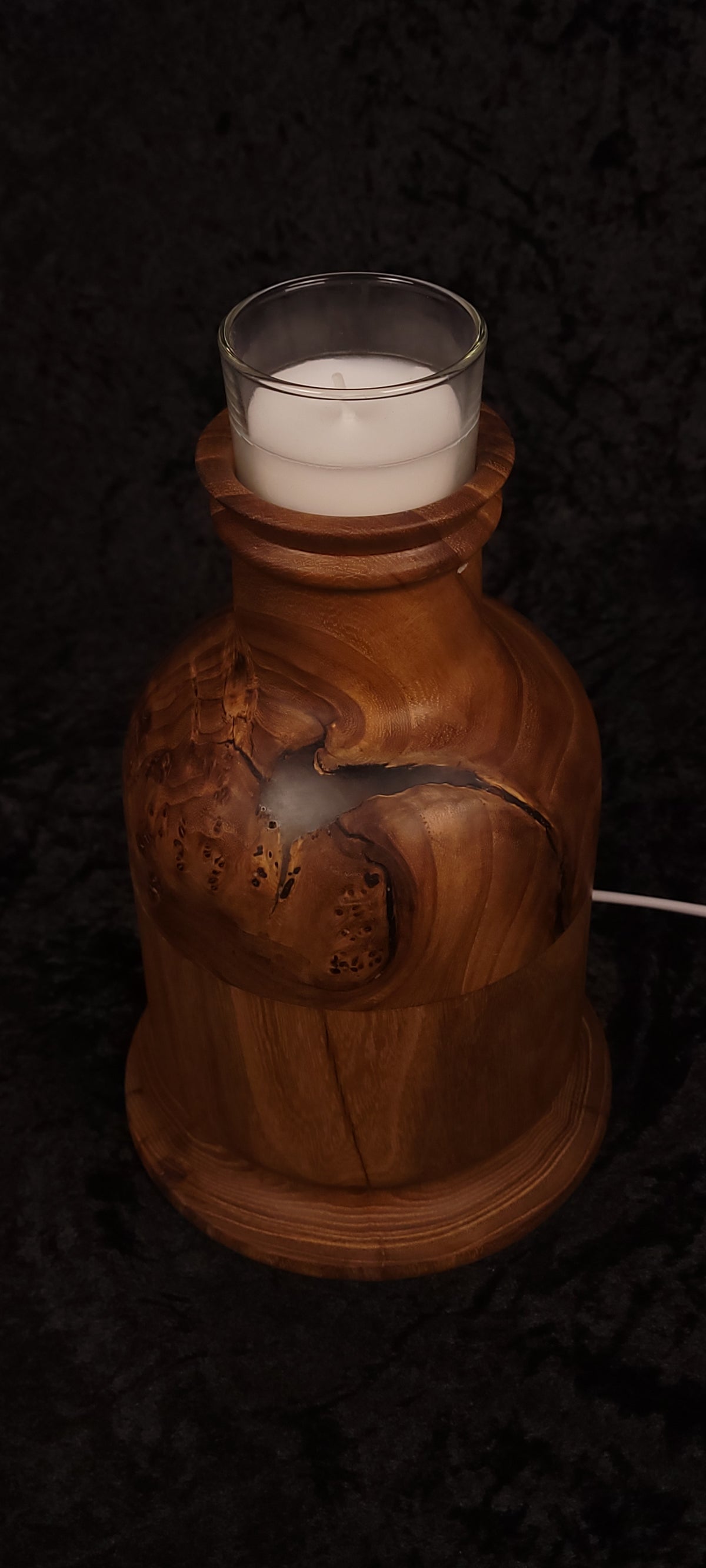 Reclaimed elm candle lamp lit with red RGB glow through natural void, glass candle cup on top