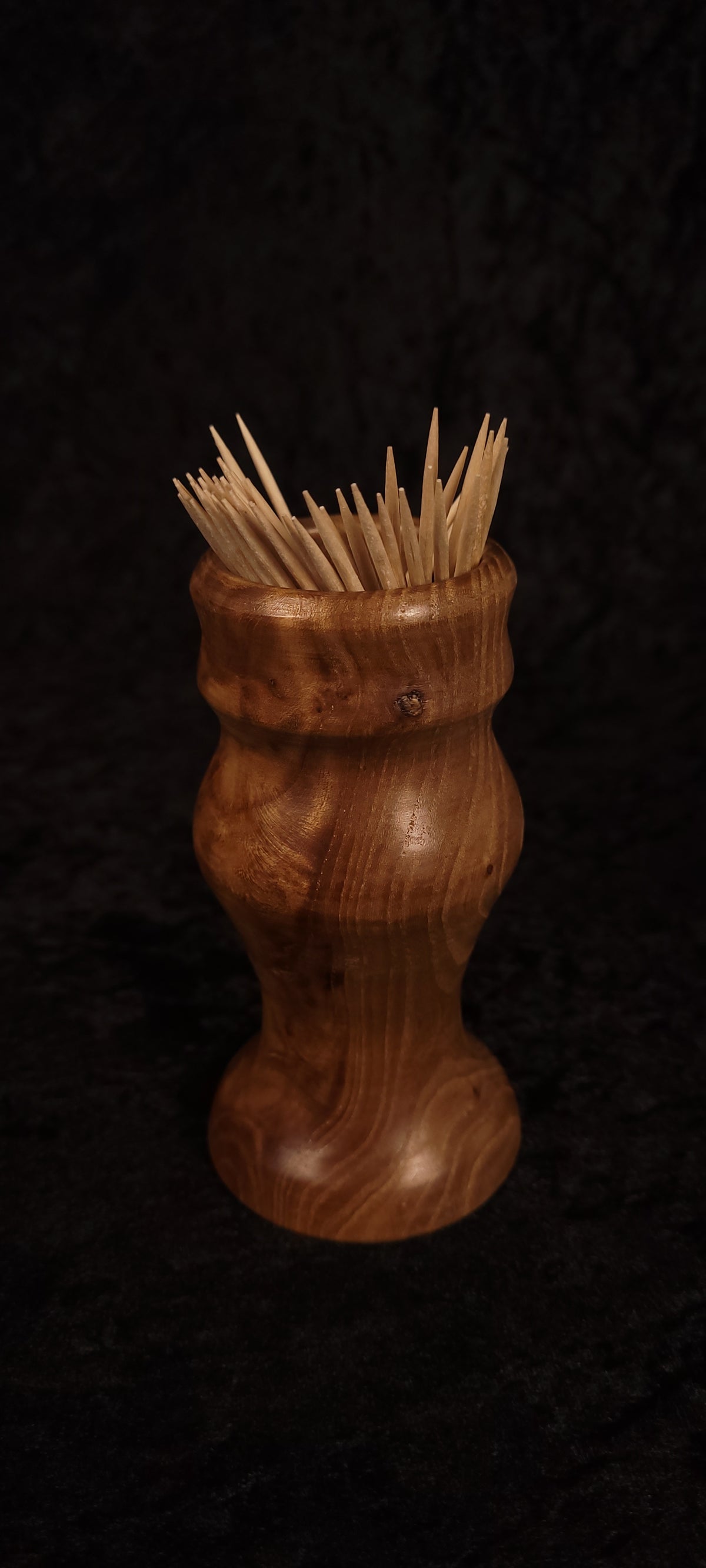 Elm wood toothpick holder filled with toothpicks, front view