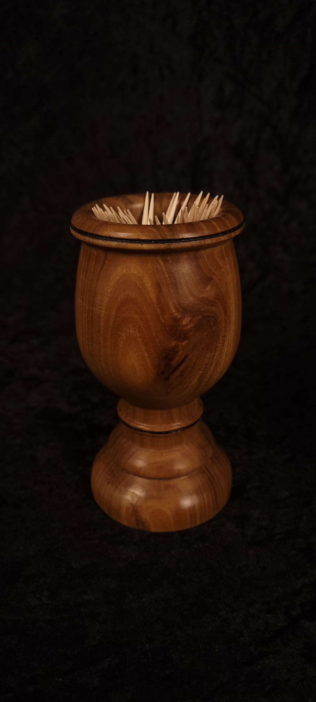 Elm wood toothpick holder filled with toothpicks, front view