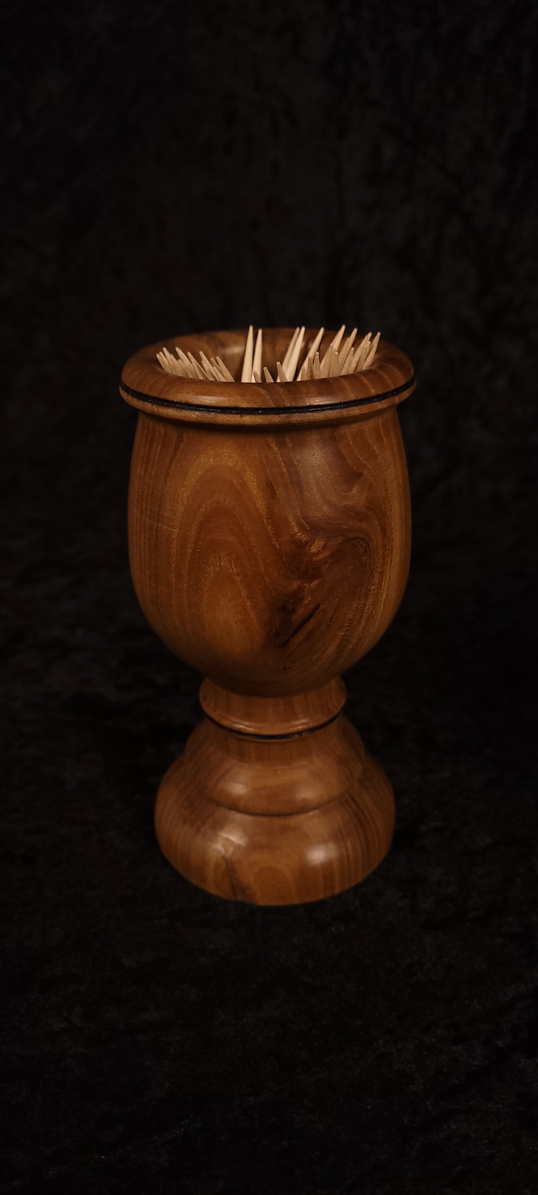 Elm wood toothpick holder filled with toothpicks, front view
