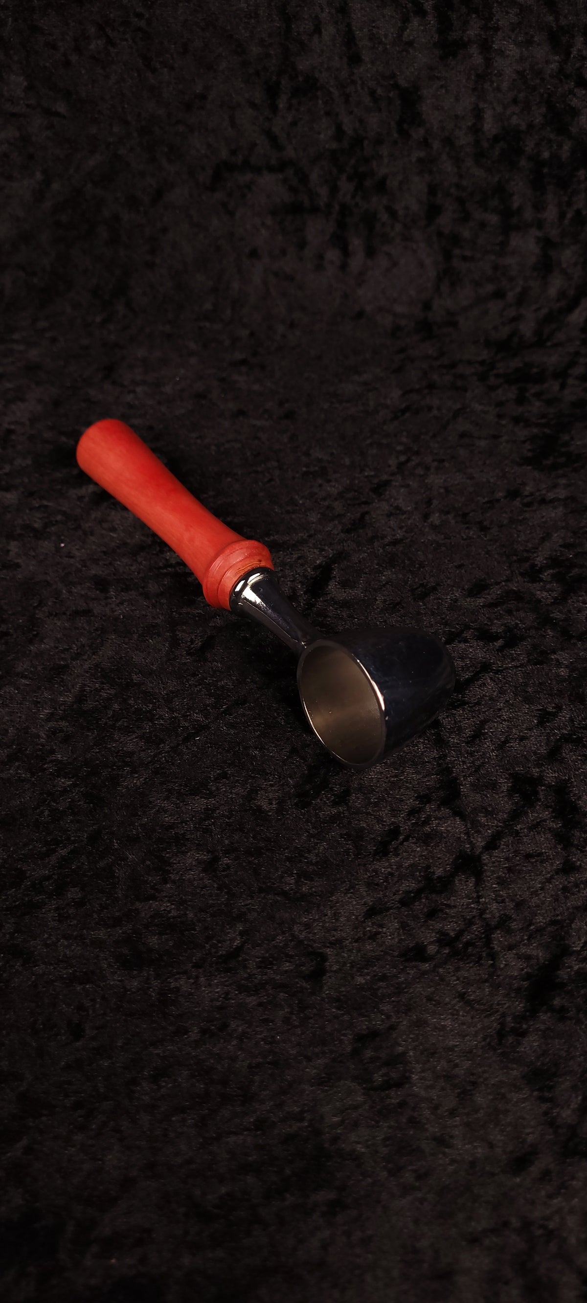 Pink Ivory wood coffee scoop laying flat on black background