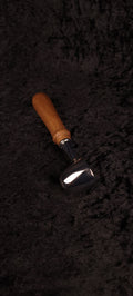 Walnut coffee scoop angled view on black background showing chrome dome and warm brown handle