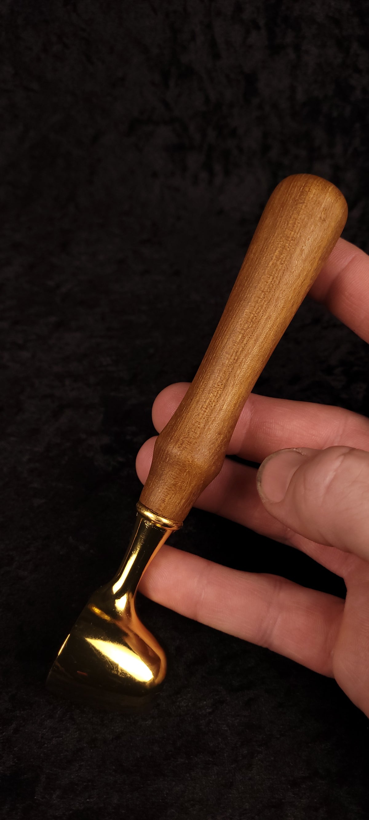 Catalpa wood coffee scoop held in hand showing scale, gold scoop and warm wood handle