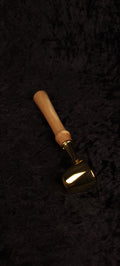Catalpa wood coffee scoop No. 2 diagonal view on black background showing gold dome scoop and tapered honey-brown handle