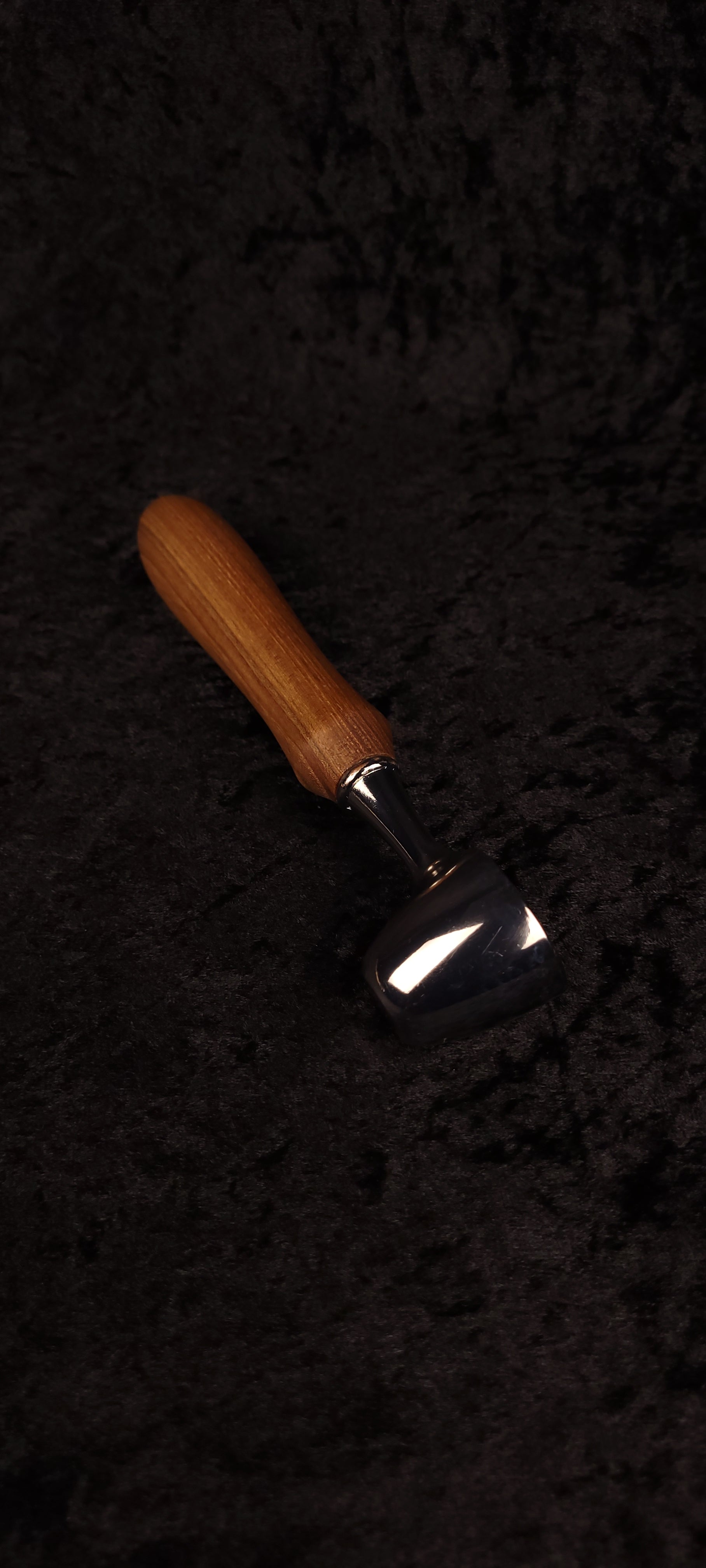 Catalpa wood coffee scoop No. 3 diagonal view on black background showing chrome dome scoop and elongated oval honey-brown handle