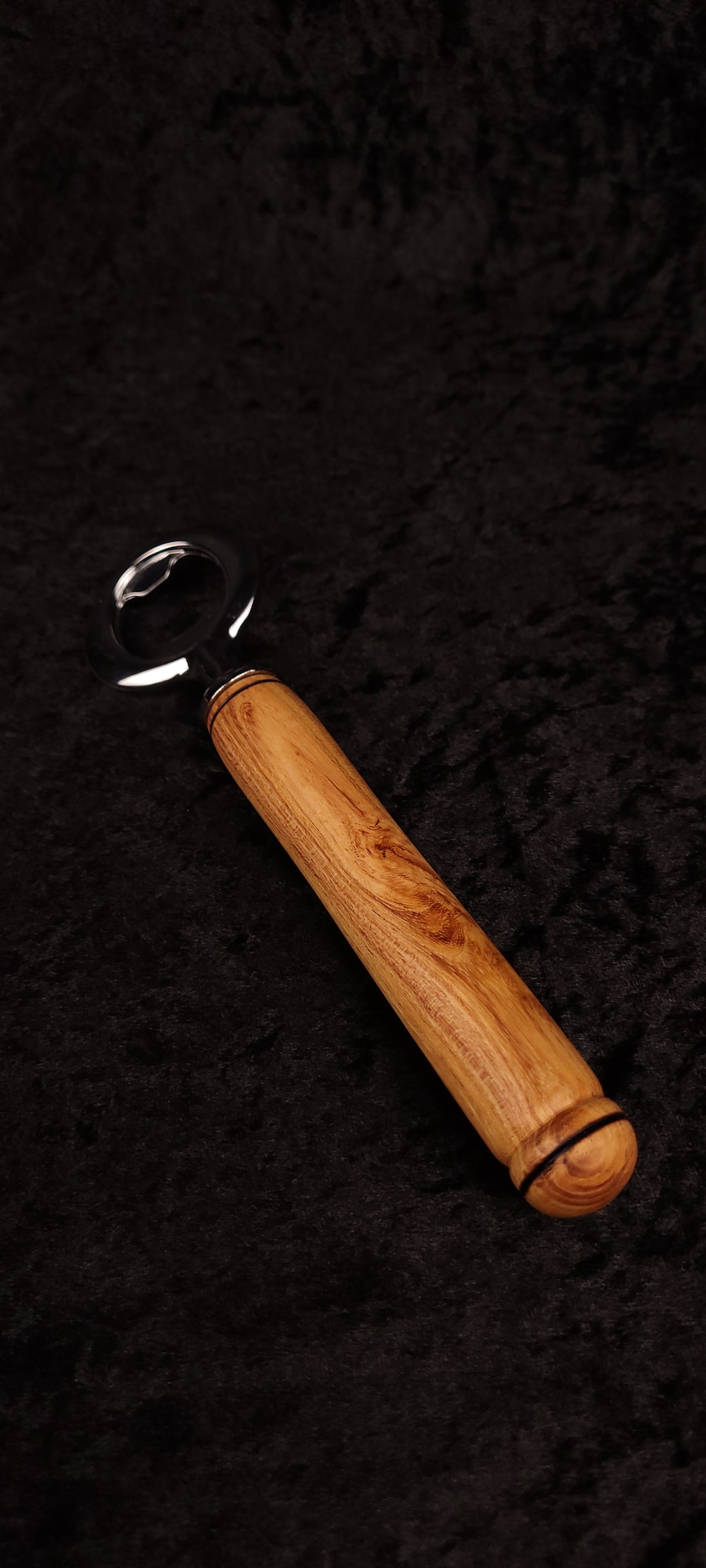 Locust wood bottle opener on dark background