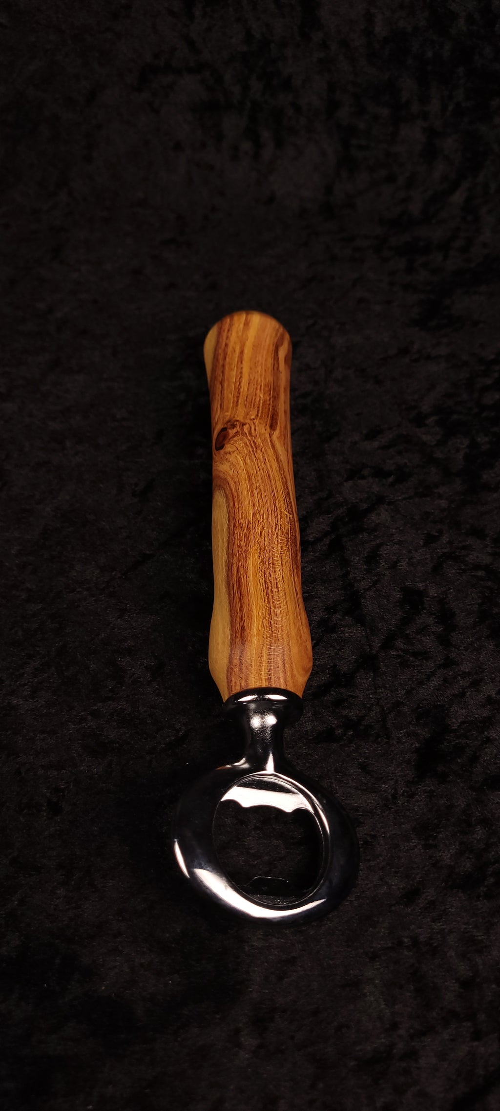 Figured locust wood bottle opener held in hand showing dramatic grain