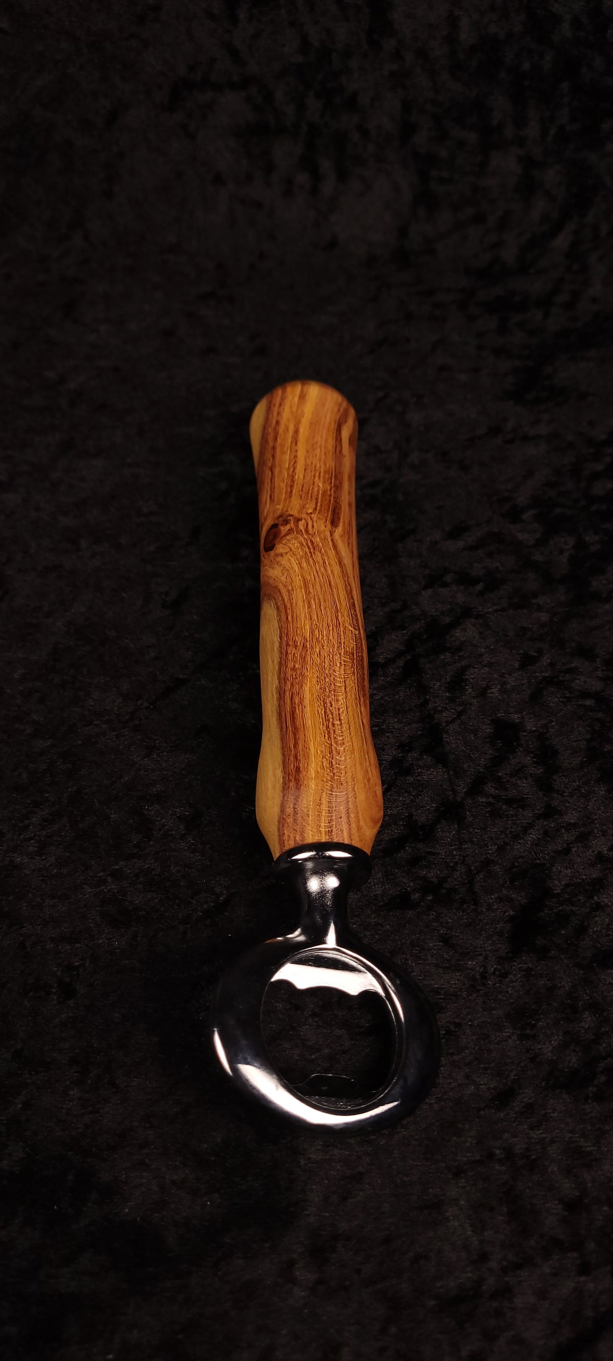Figured locust wood bottle opener held in hand showing dramatic grain