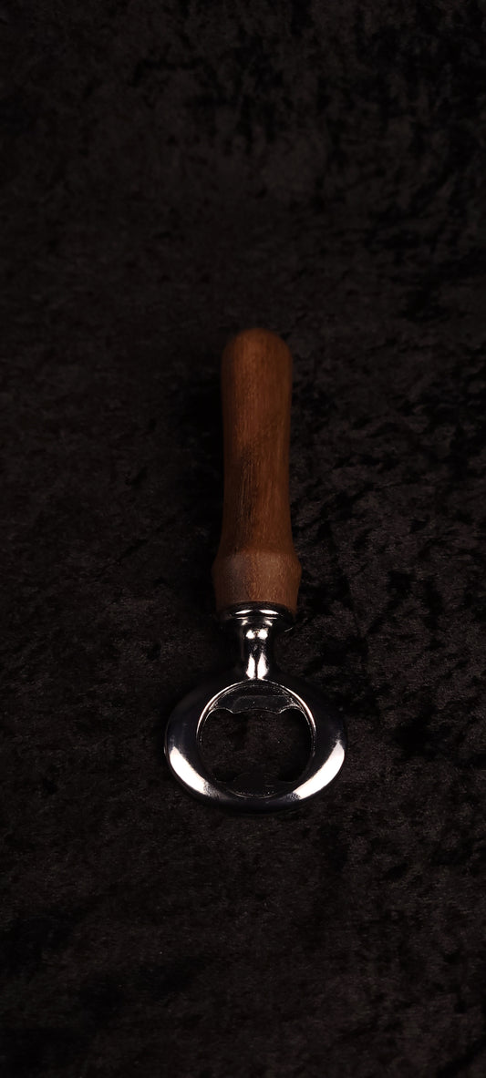 Walnut wood bottle opener on dark background, top view
