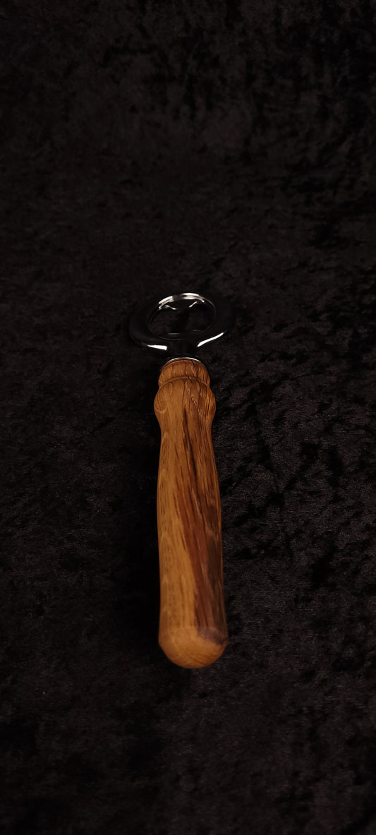 Oak wood bottle opener on dark background, top view