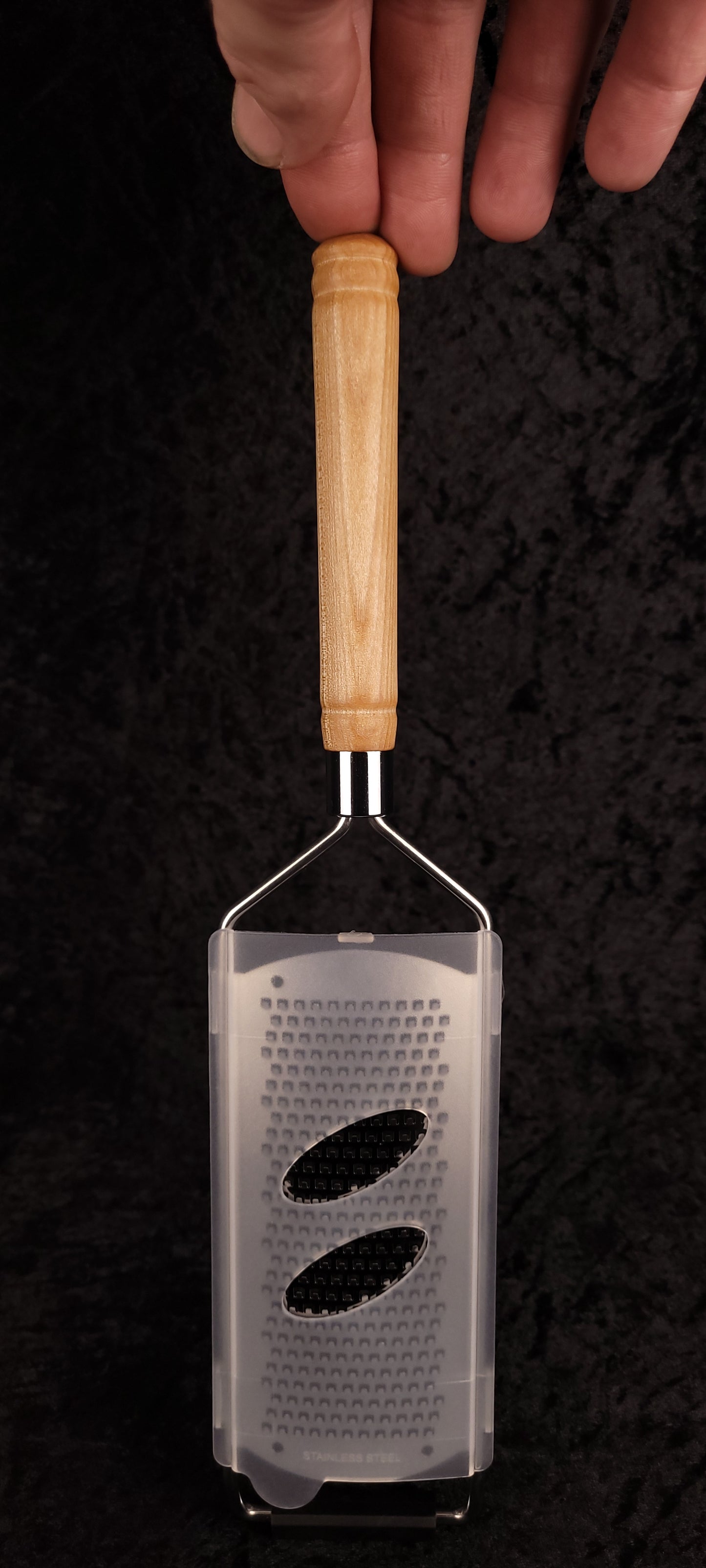 Curly maple grater held in hand showing grip and grating surface