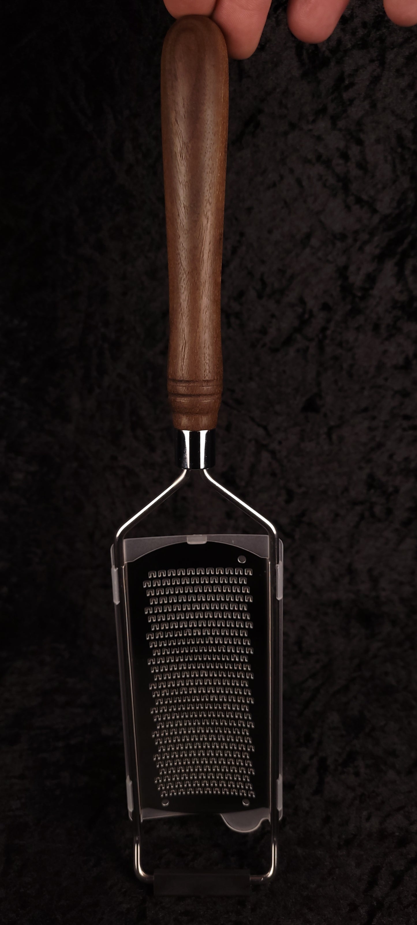 Handcrafted walnut handle rasp grater held vertically