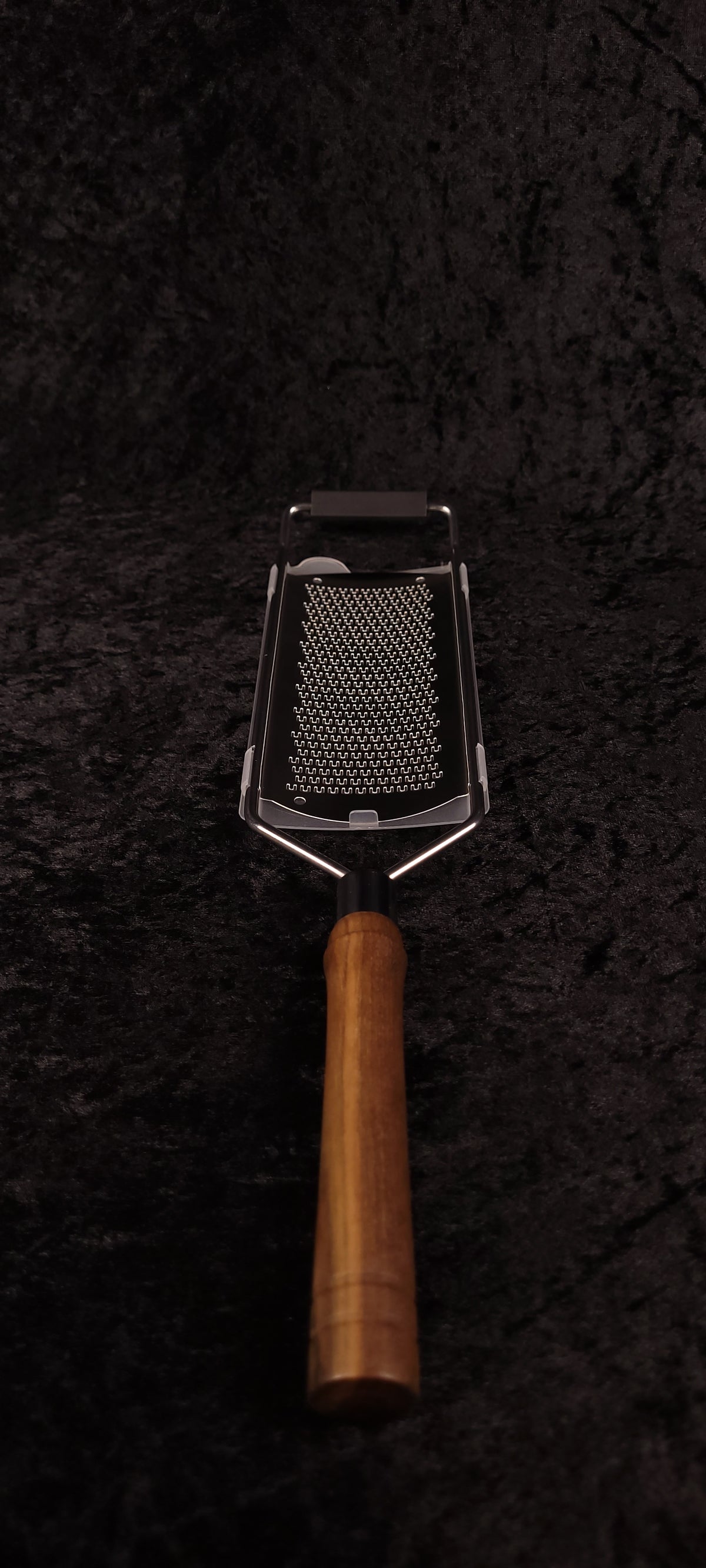 Walnut rasp grater without guard showing rasp surface, top-down