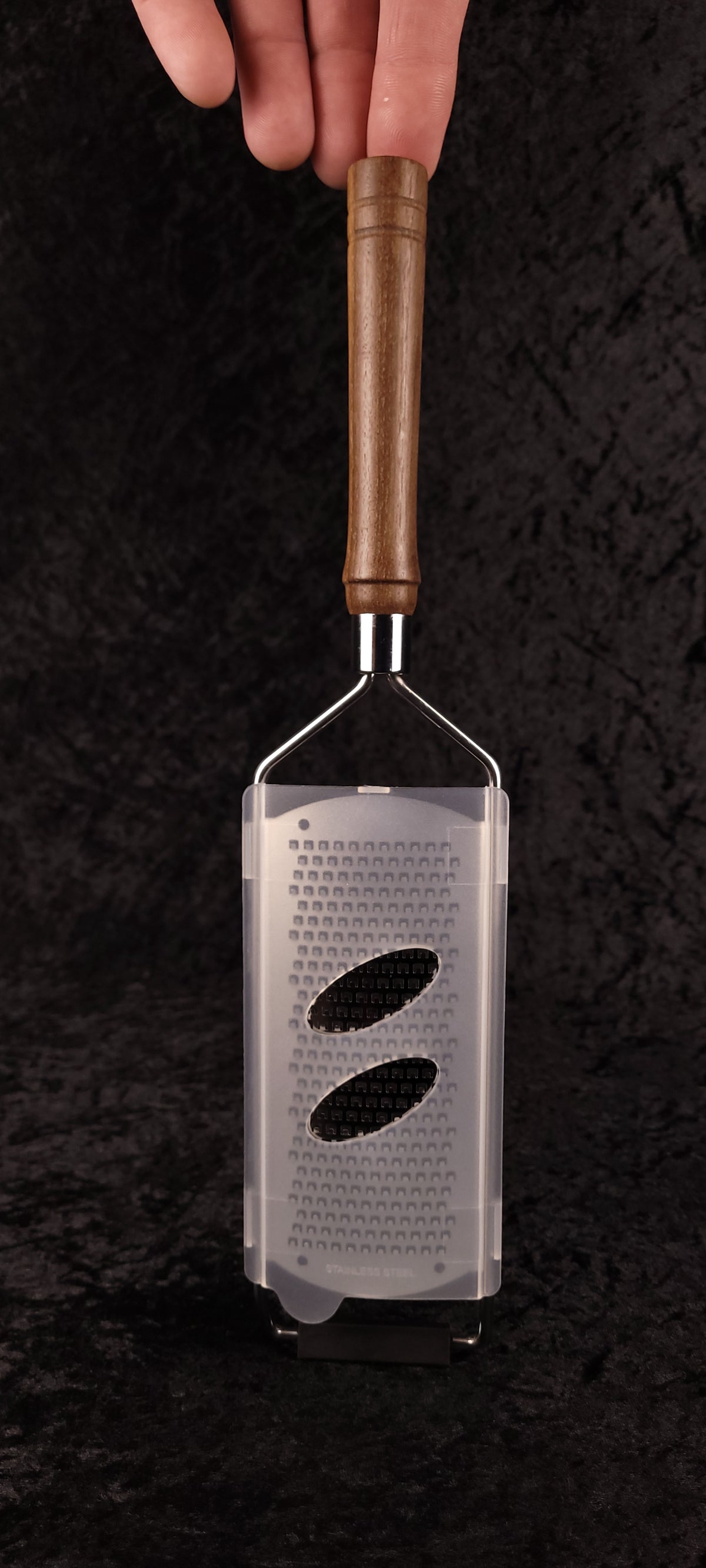 Walnut rasp grater held vertically showing handle and grating head