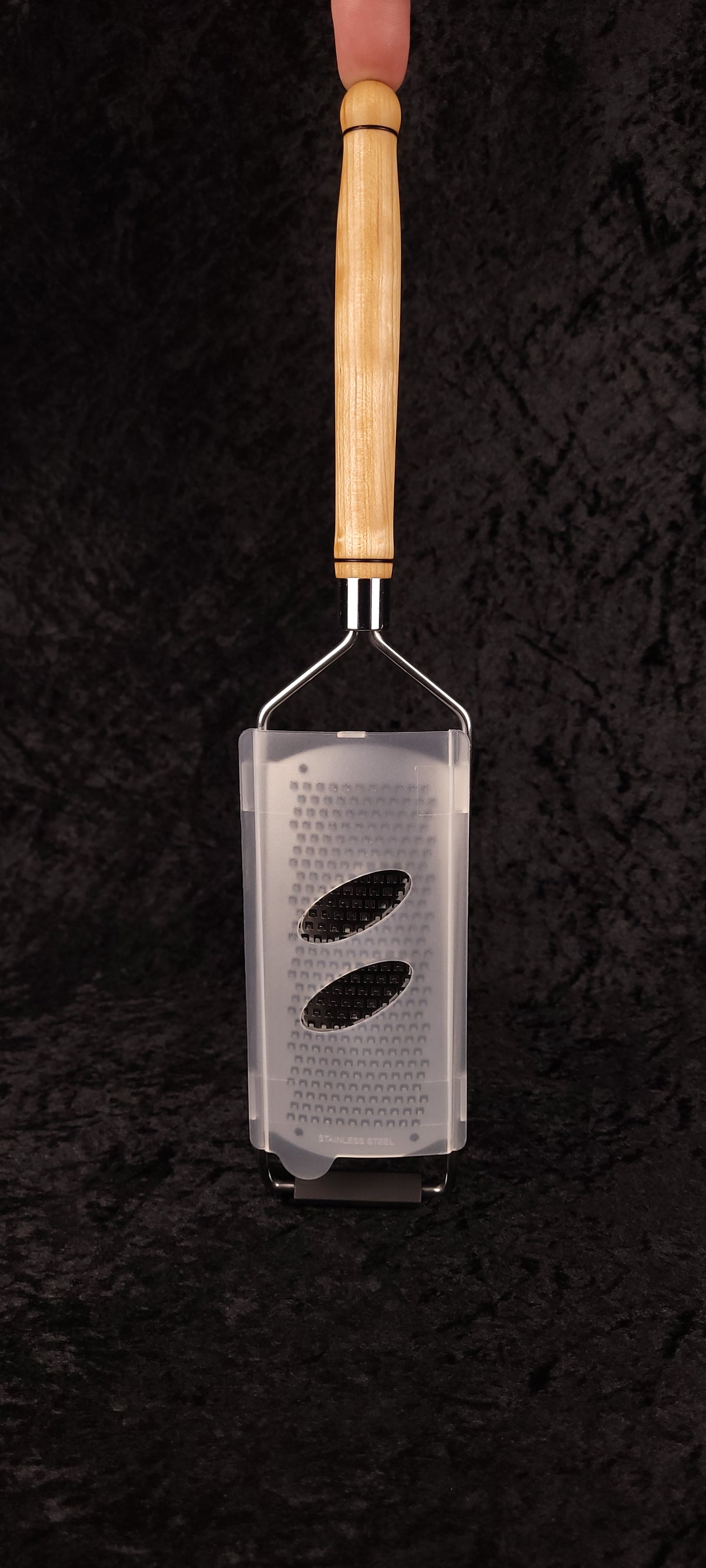 Maple flat grater held up showing grating surface with plastic guard