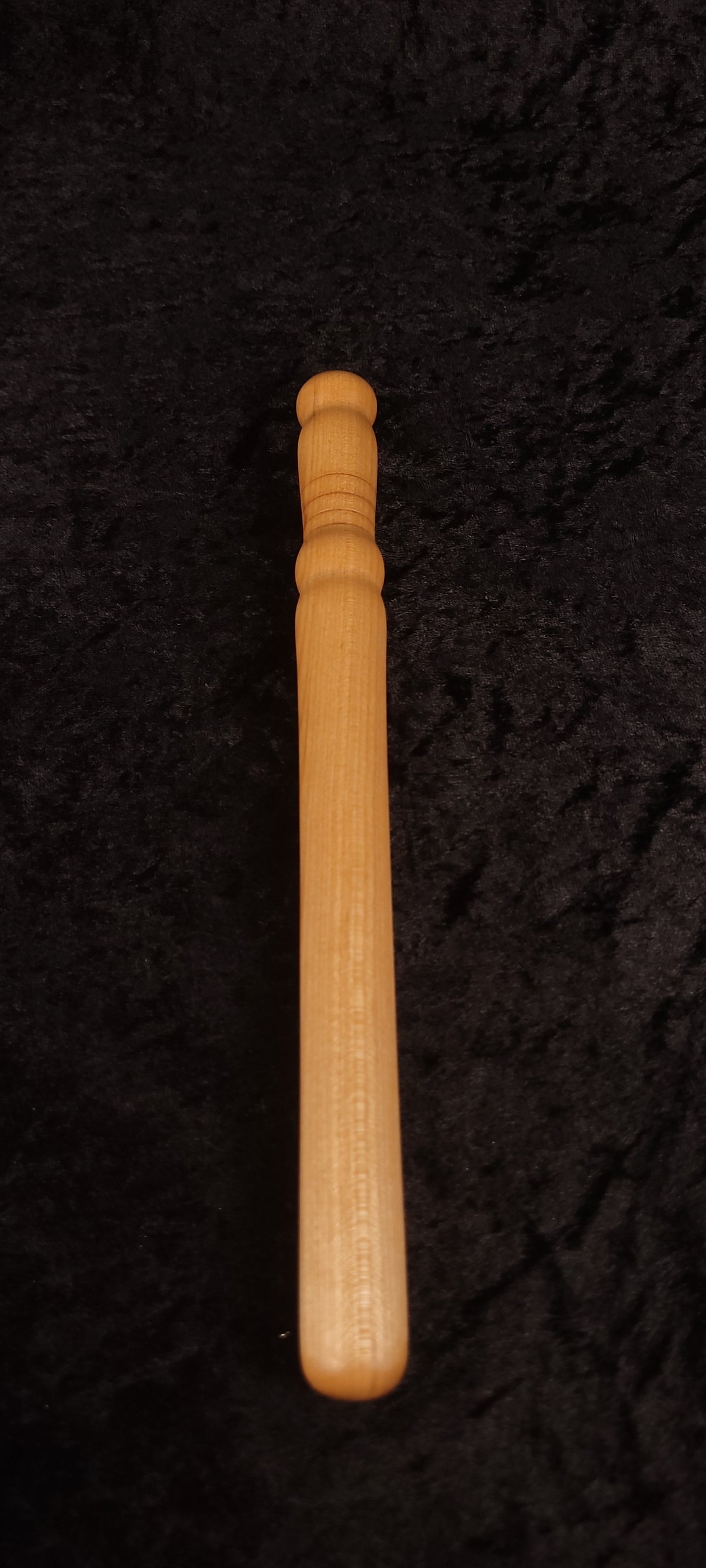 Curly maple spurtle full length top-down view on dark background