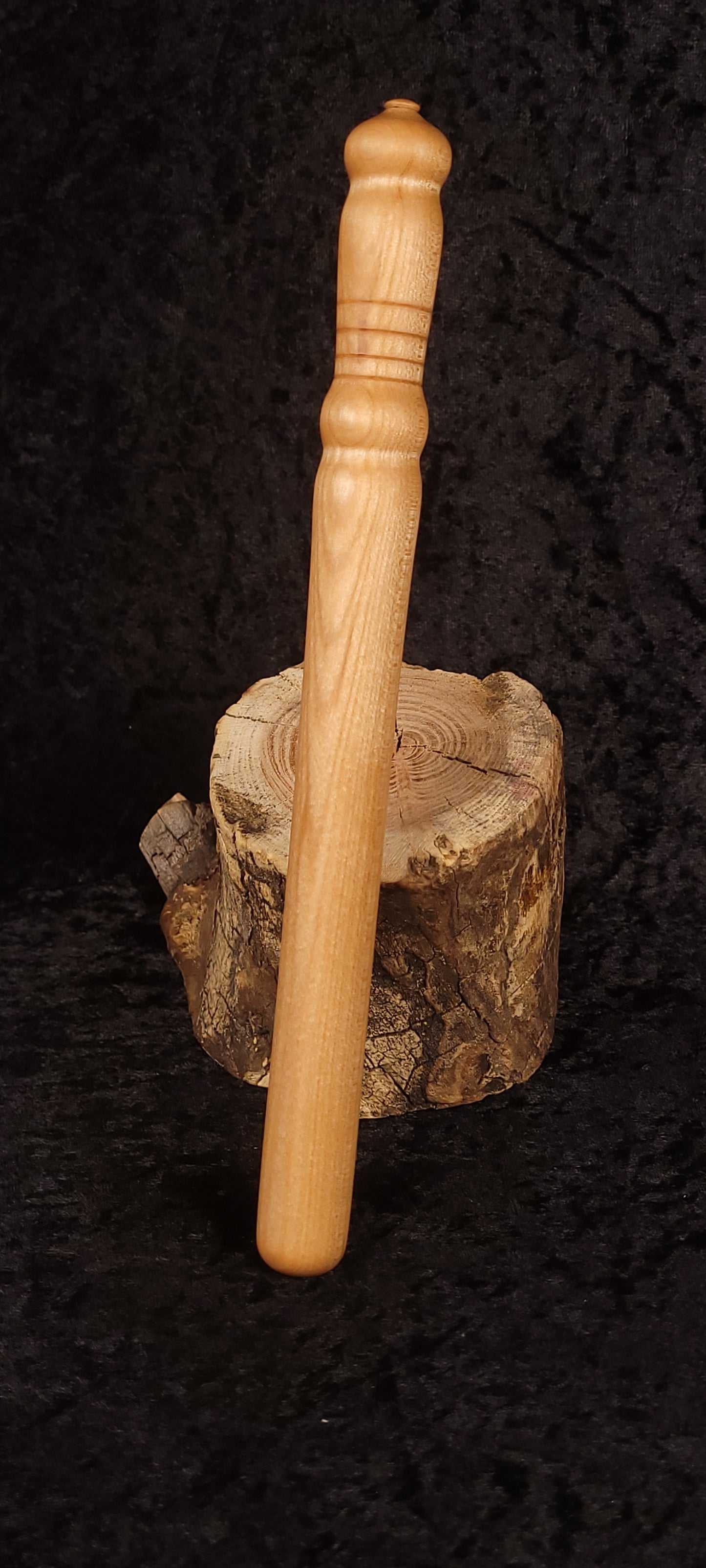 Curly maple spurtle on wood round, alternate angle showing turned rings
