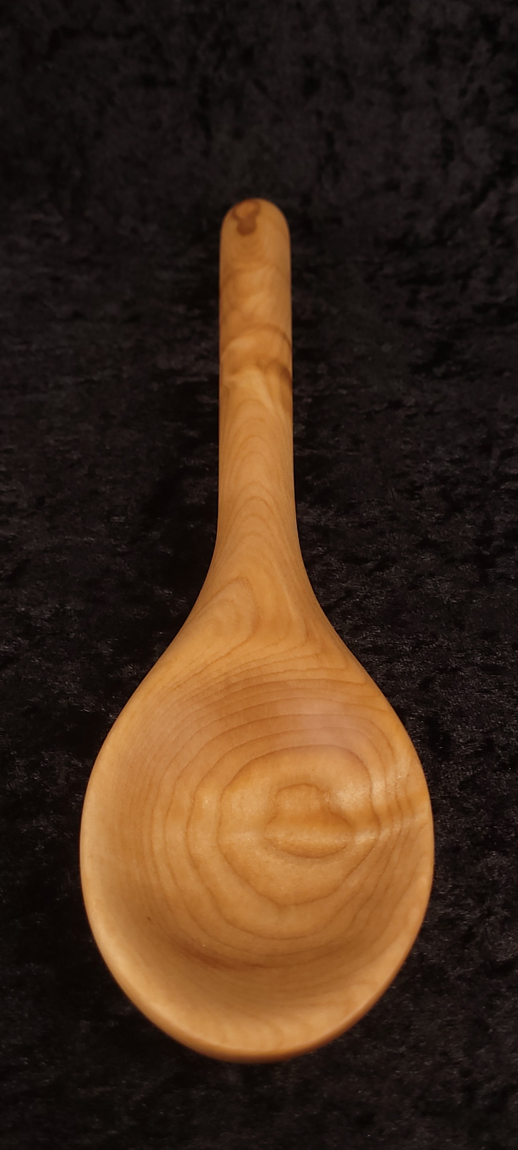 Handcrafted curly maple spoon front view showing deep bowl and figuring