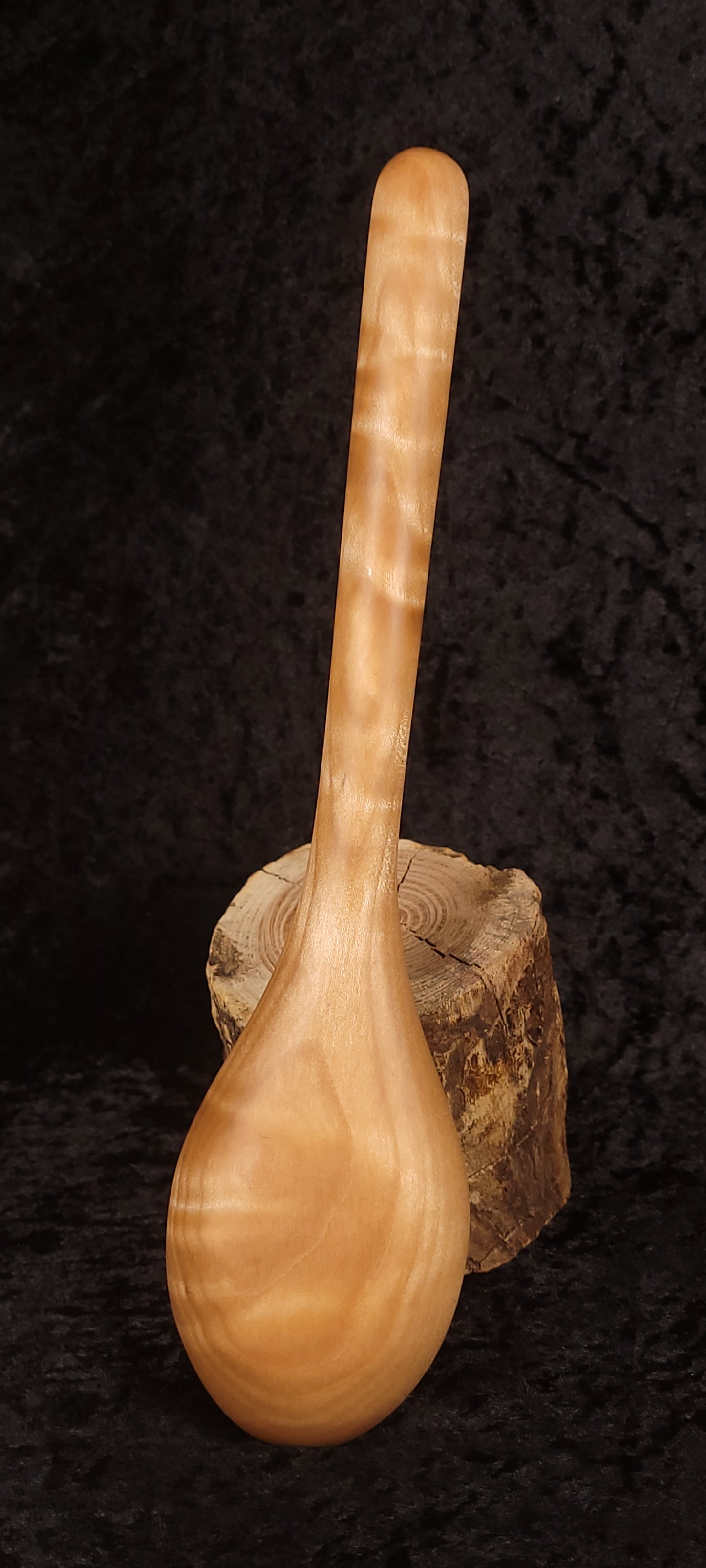 Curly maple spoon alternate side view on wood round