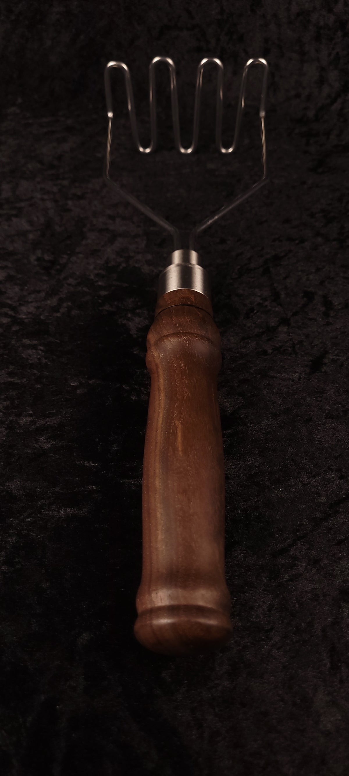 Close-up of walnut handle ferrule and wire head connection, angle